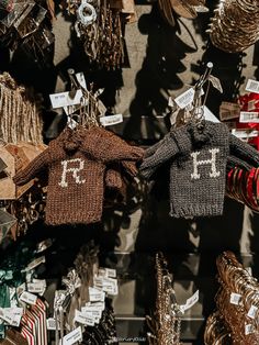 two knitted mittens hanging from hooks in front of other christmas decorations and ornaments