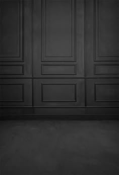 an empty room with black walls and wooden paneling on the wall is shown in this image