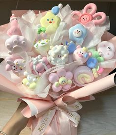 a pink bouquet with teddy bears and other baby items in it's wrapper