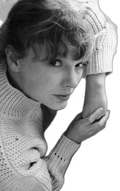 black and white photograph of a woman with short hair wearing a knitted sweater over her shoulders