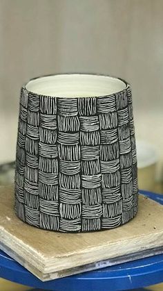 a black and white bowl sitting on top of a wooden table next to a blue tray