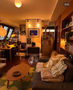 a living room filled with lots of furniture and bookshelves next to a window