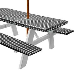 a picnic table with an umbrella on top and black and white checkerboard pattern