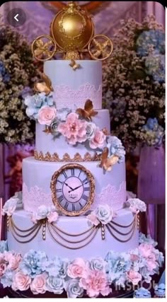 a three tiered cake decorated with flowers and a clock on the top is purple