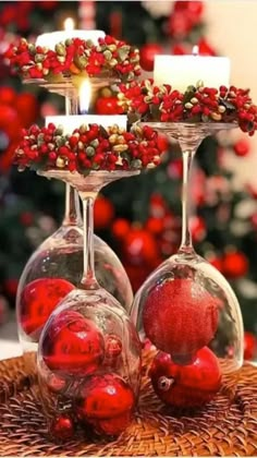 two wine glasses filled with red berries and candles