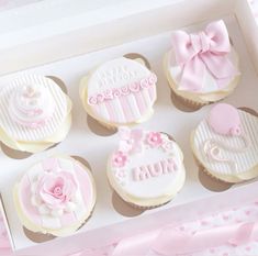 decorated cupcakes in a white box with pink bows