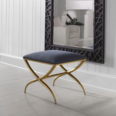 a mirror sitting on top of a white wall next to a blue bench and chair