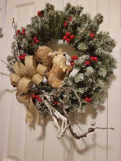 a christmas wreath with two teddy bears on it