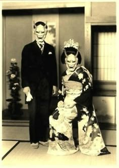 an old black and white photo of two people dressed up in geisha garb