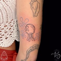 a woman's arm with an octopus tattoo on the left side of her arm