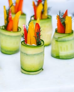 there are many small cups that have vegetables in them on top of each other and garnished with herbs