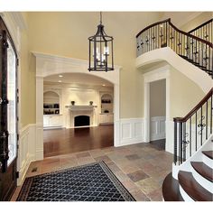 an open floor plan with stairs and chandelier