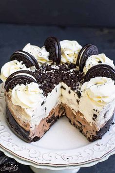 a cake with oreo cookies and cream frosting on it sitting on a plate