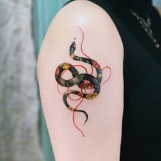 a woman's arm with a snake tattoo on it