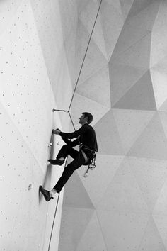 a man climbing up the side of a wall on a rock climber's rope