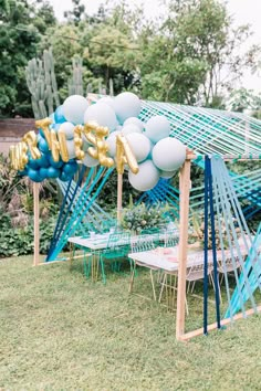 an outdoor party with balloons and chairs in the shape of letters that spell out love