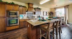 a kitchen with wooden cabinets and an island in front of the stove, oven, microwave and dishwasher