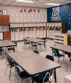 an empty classroom with desks and bookshelves on the wall in front of them