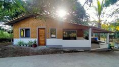 a small white house with wooden doors and windows