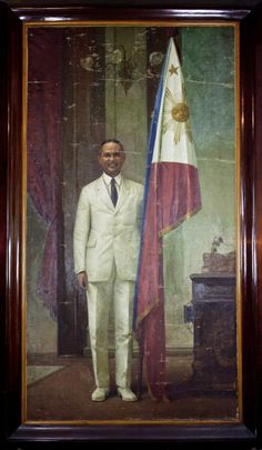 a man in a white suit and tie standing next to a flag on a painting