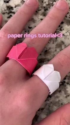 a hand holding an origami heart ring on it's finger with the text paper rings tutorials 3