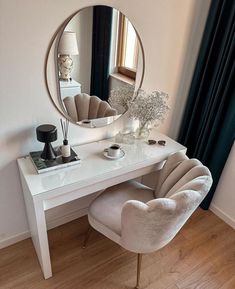 a white desk with a mirror on it and some chairs in front of the table