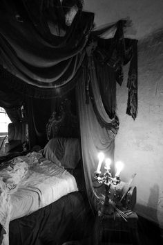 a bed with two candles on it in a room that looks like an old fashioned bedroom