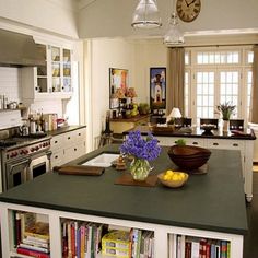 a large kitchen with an island in the middle and lots of cabinets on both sides