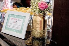 a photo frame sitting on top of a table next to a vase filled with flowers