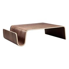 a wooden table that is on top of a white wall and has a curved edge