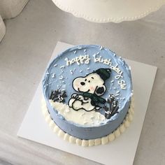 a blue frosted birthday cake with a cartoon dog on it