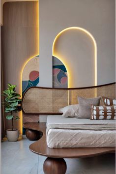 a bed sitting in the middle of a room next to a table and potted plant