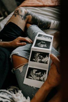 a man laying on top of a bed holding two pictures