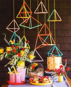 a table topped with cakes and flowers on top of a wooden table