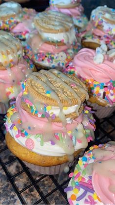 there are many decorated cookies and cupcakes on the cooling rack