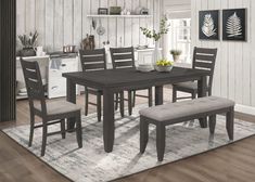 a dining room table and chairs with a bench in front of it on a rug