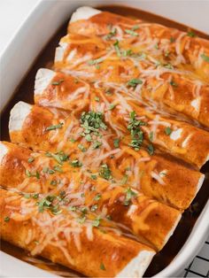 baked enchiladas in a white casserole dish