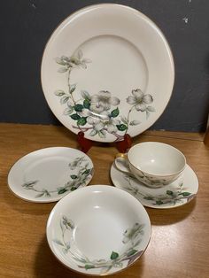 a table topped with plates and cups on top of a wooden table