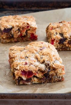 four pieces of fruit and oatmeal bars sitting on top of a baking sheet