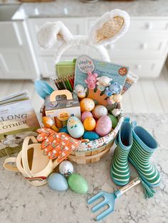 a basket filled with lots of different types of easter eggs next to gardening utensils