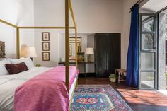 a bedroom with a canopy bed and rugs on the floor