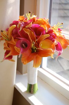 a bouquet of flowers sitting on top of a window sill