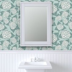 a white sink sitting under a bathroom mirror next to a wall mounted faucet