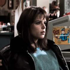 a woman sitting in front of an old computer