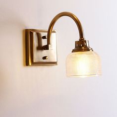 a light that is on the wall next to a white wall with a glass shade