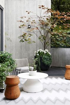 an outdoor patio with white furniture and potted plants