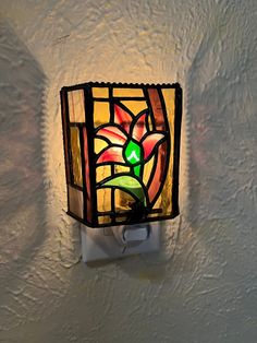 a stained glass light fixture on the wall