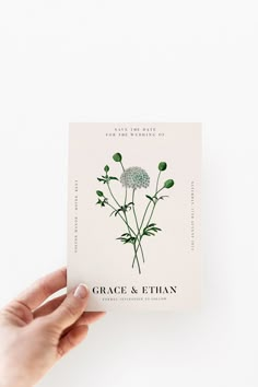 a person holding up a card with a flower on it that says grace and ethan