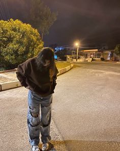 a person standing on a skateboard in the middle of an empty street at night