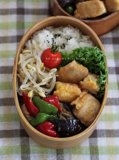 two wooden bowls filled with food on top of a checkered tablecloth covered table